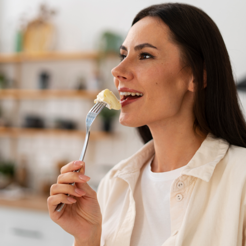 Paladar e olfato: mulher comendo queijo fazendo referência ao paladar.