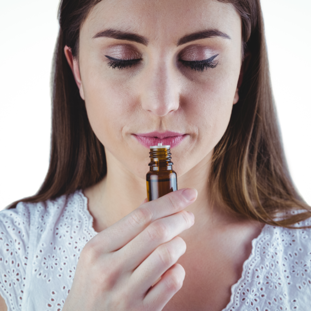 Tipos de cheiro, mulher cheirando um frasco com aroma.